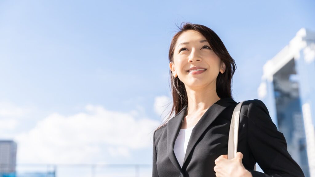 晴々とした表情のスーツを着た女性