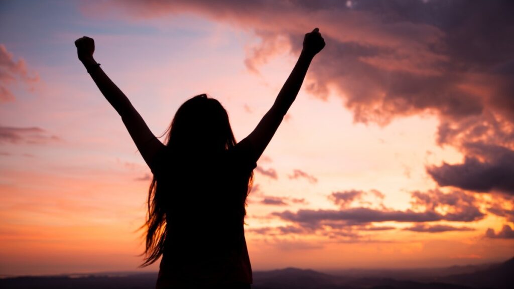 成功を示す女性 - 夕空のシルエット