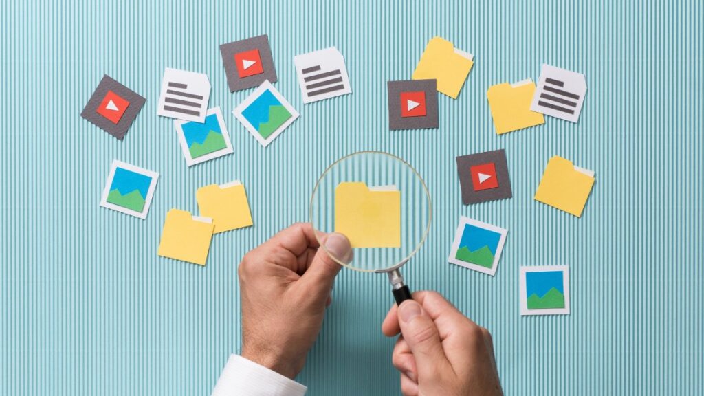 ファイルの検索と分析: 拡大鏡を使ってフォルダを拡大する男性