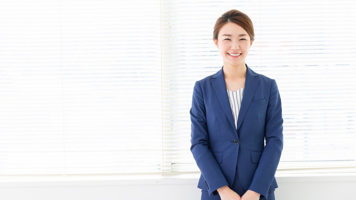 笑顔で笑うスーツ姿の女性