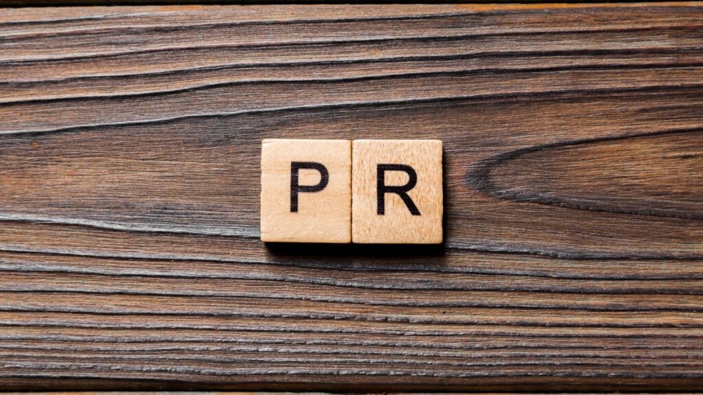 木のブロックに書かれた PR ワード。テーブルの上の広報テキスト、コンセプト。