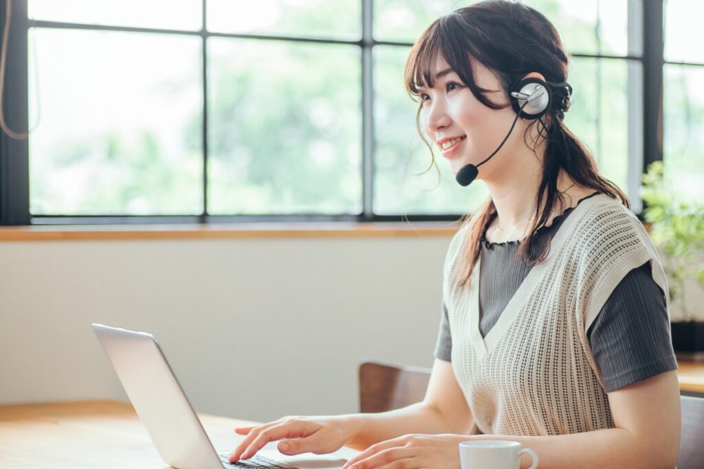 ヘッドセットをつけた女性が在宅ワークをしている