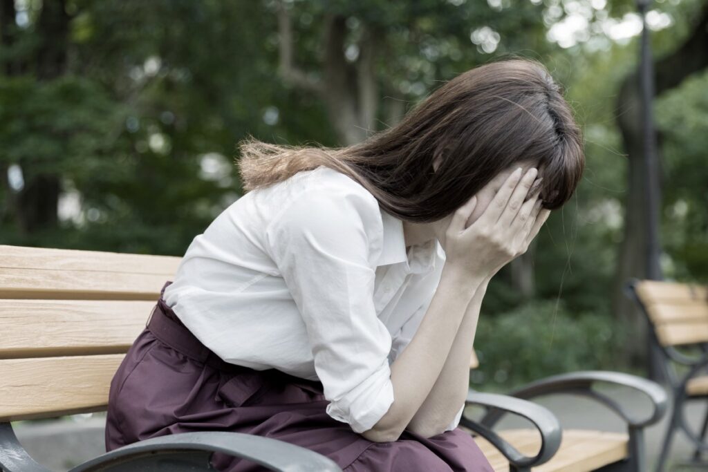 ベンチで絶望する女性