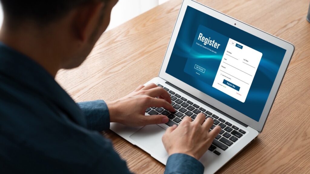 パソコンを開いと登録をしている男性