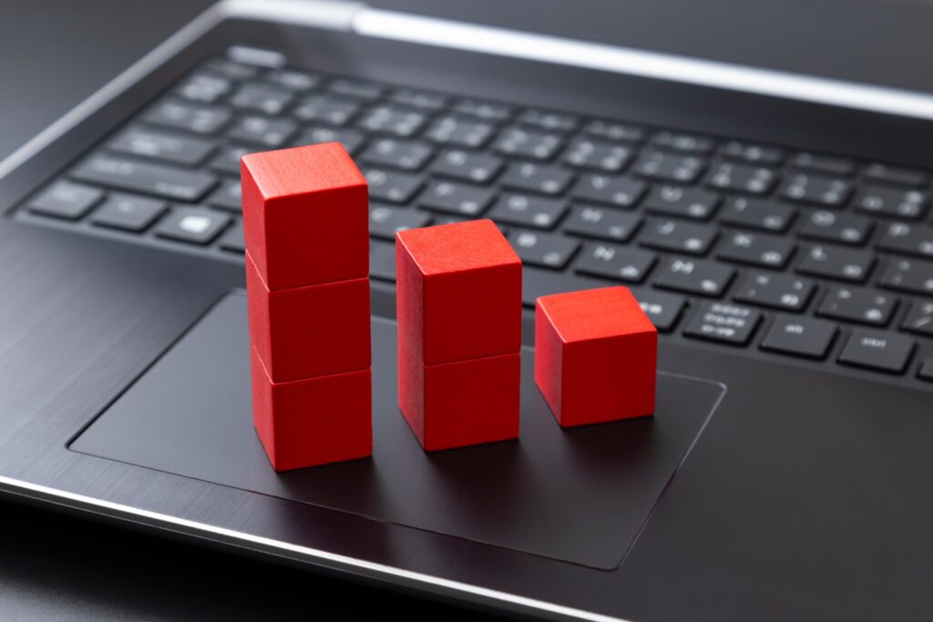 ノートPCのパッドの上に赤いブロックが棒グラフのように右肩下がりで3つ並んでる